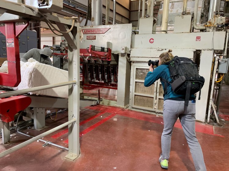 A photographer taking photos in a cotton gin.