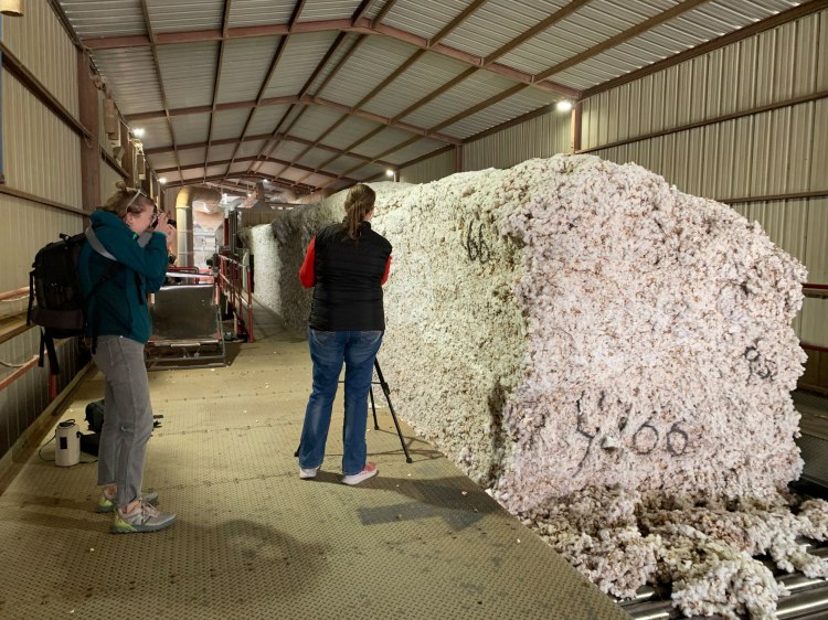 A photographer recording video in a cotton gin.